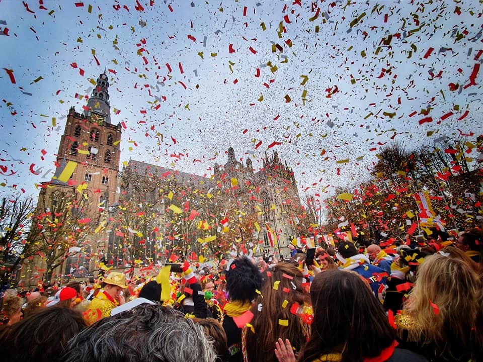 Confetti boven un menigte carnavalsvierders bij de Sint-Jan